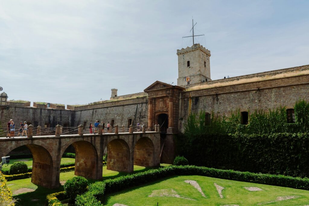A bridge over a lush green field next to a tall building