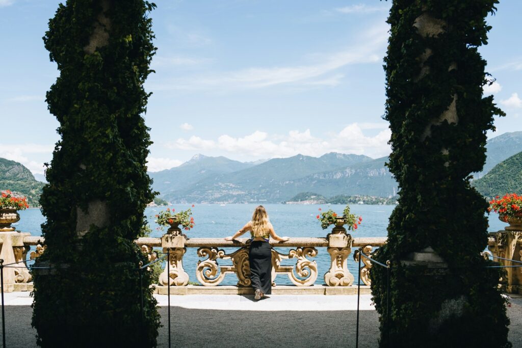 A woman sitting on a bench looking out over a lake
