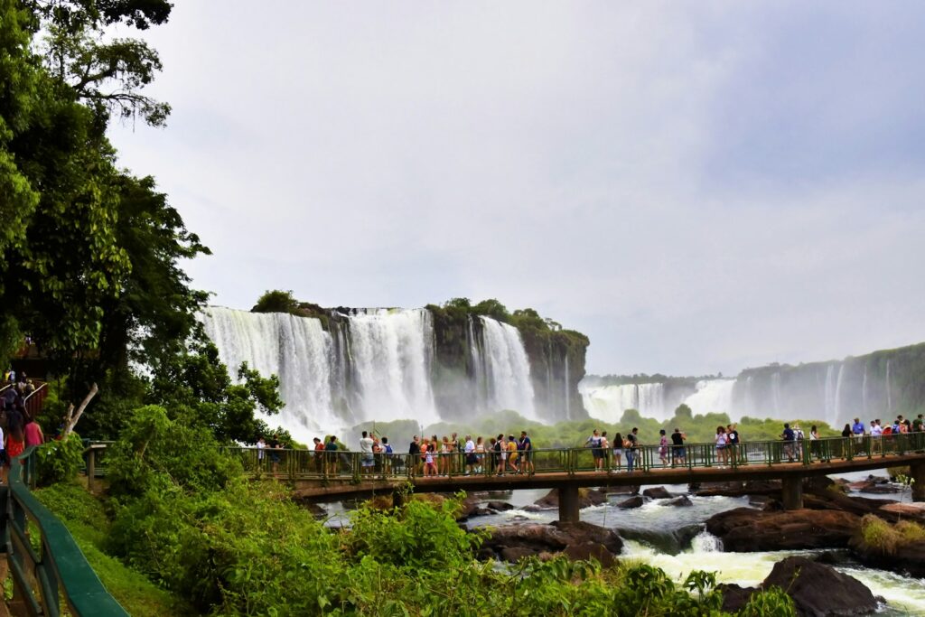 a group of people standing on a bridge over a river