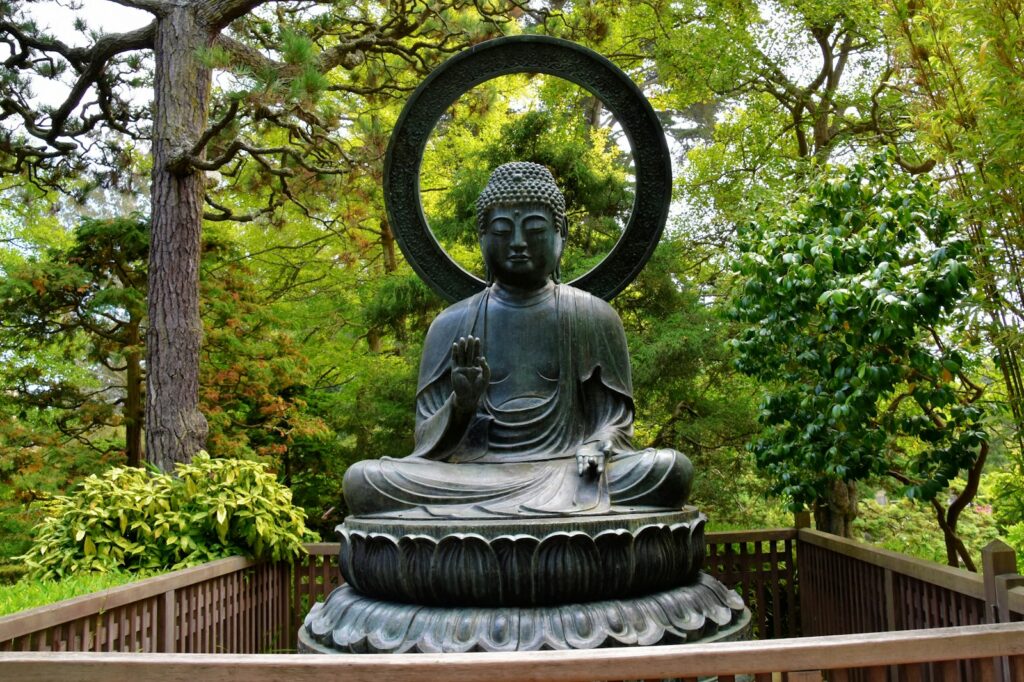 a statue of a buddha in a park setting